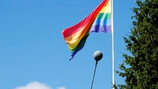 Pride lippu liehuu lasipuheltajapatsaan vieressä