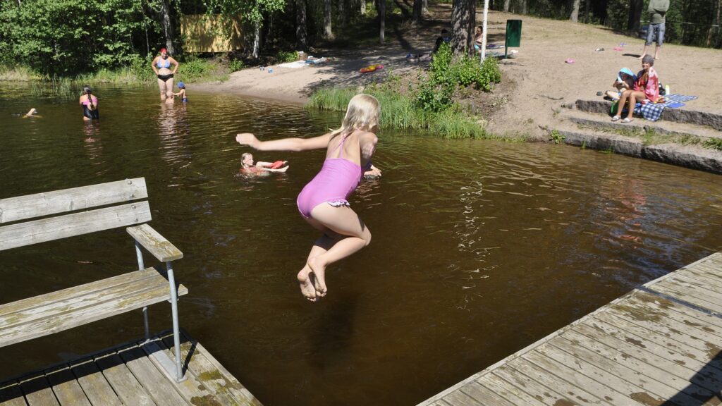 Tyttö hyppäämässä järveen kolmilammilla