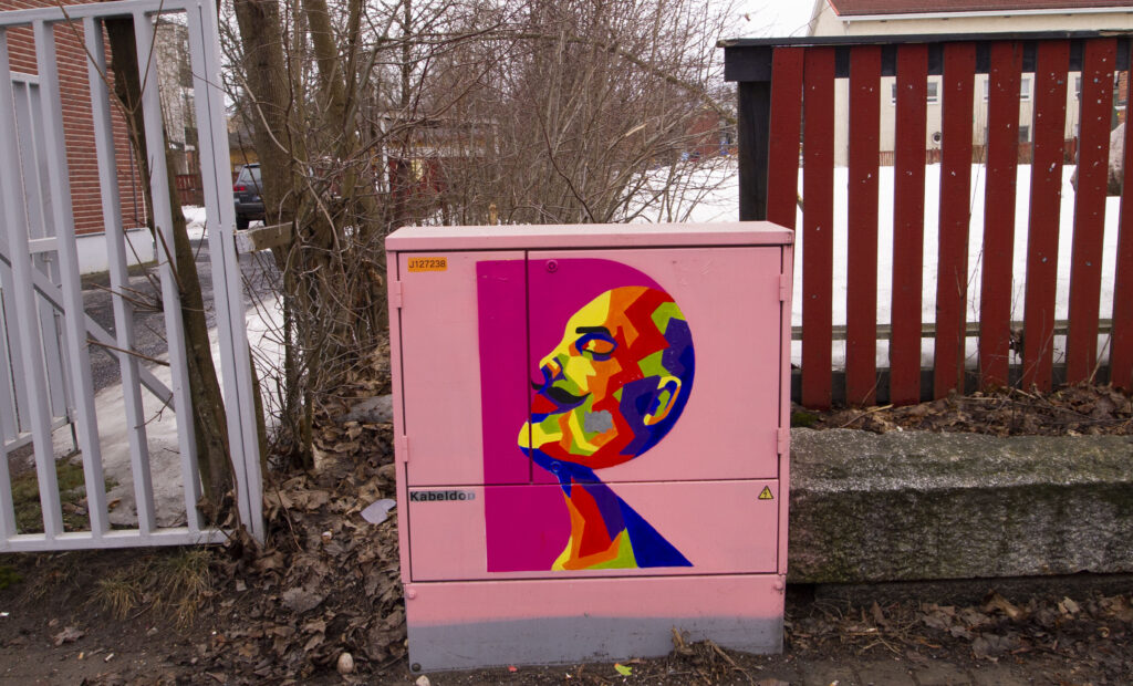 Vaaleanpunainen sähkökaappi, johon on maalattu Lenin kuva
