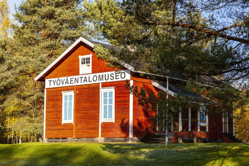 Punainen puutalo, jossa lukee "Työväentalomuseo". Kesäinen ilma, vihreää nurmea ja puita.