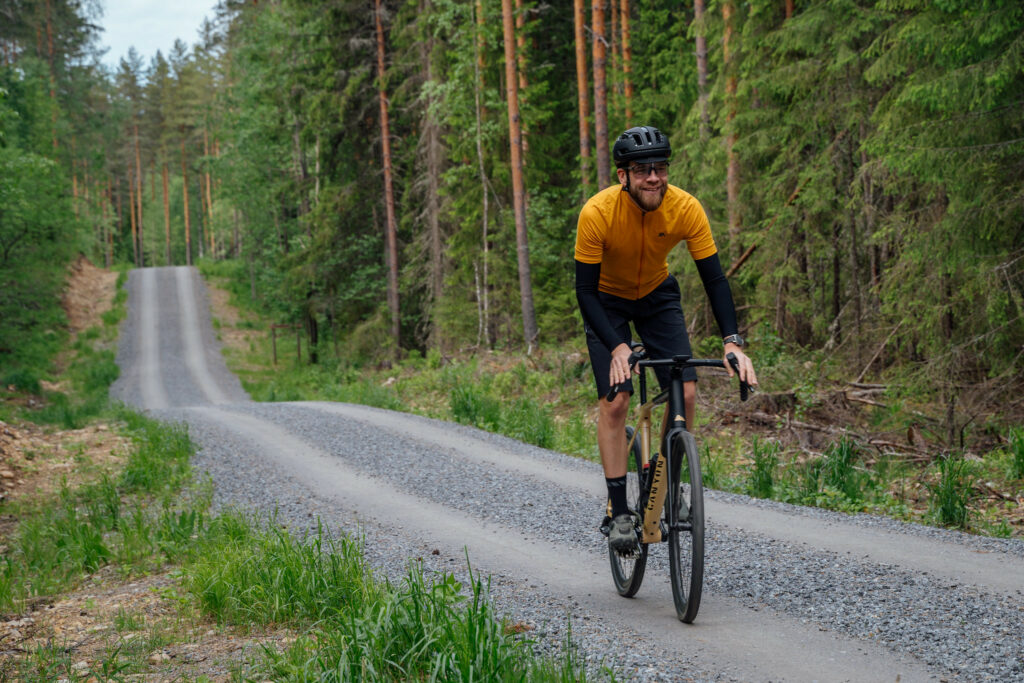 mies pyöräilee maantiellä