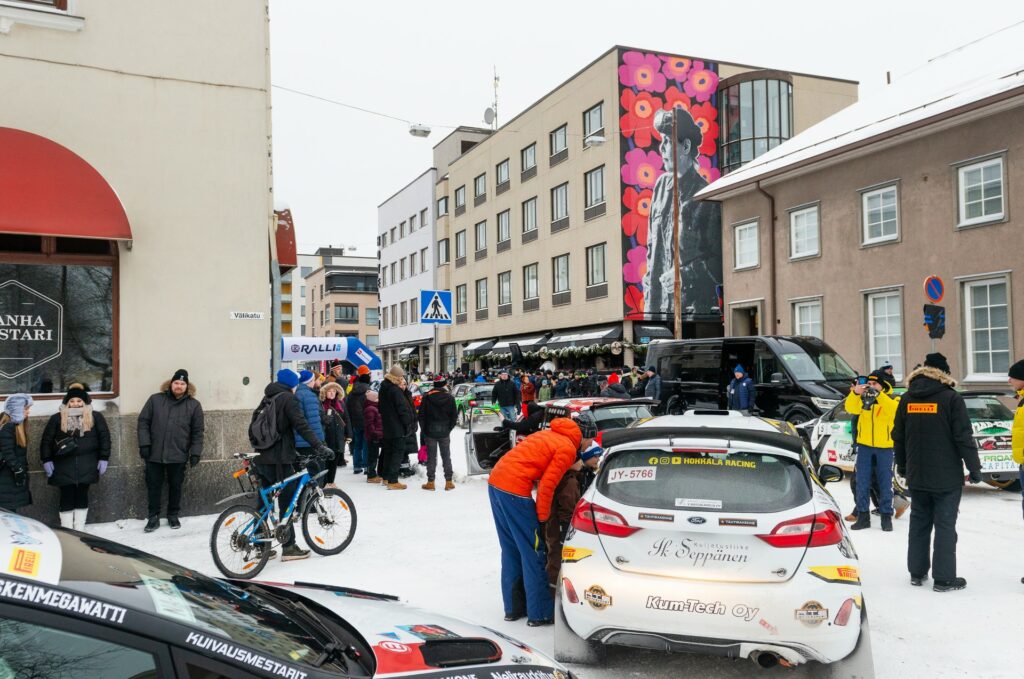 Riihimäen keskustassa lumisella kadulla paljon ihmisiä ja autoja.